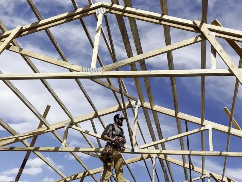 Crew member working among newly set roof trusses