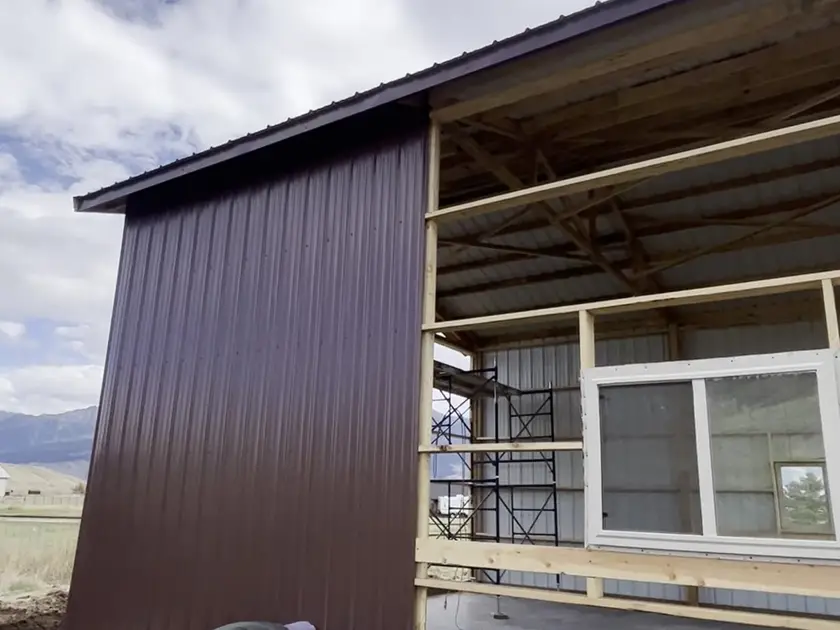 Pole barn partly sided in brown steel with a window framed in
